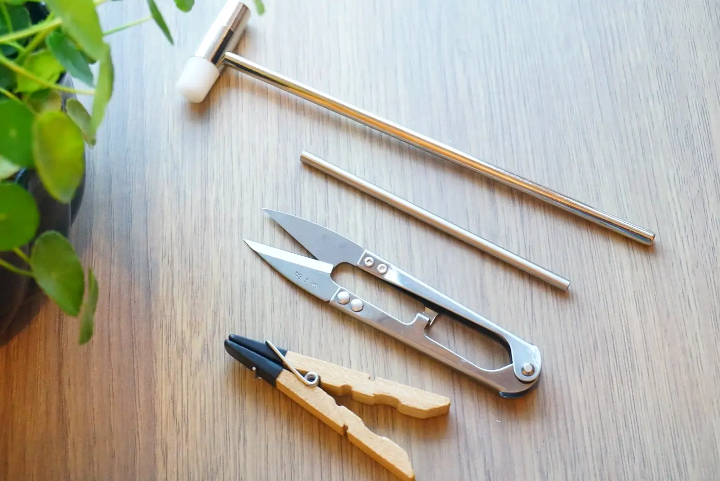 String art tools displayed from left to right: nail holder, thread scissors, nail tube, and hammer. Essential equipment for crafting intricate string art designs.