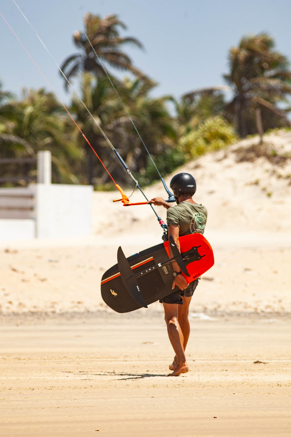 An early morning kite foiler heads to the beach, taking advantage of the gentle breeze with the AM Foiling Club before breakfast.