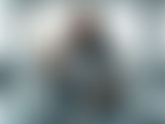 Um homem em traje de astronauta senta-se numa mesa de conferência futurista, olhando atentamente para uma pedra que segura.