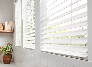These faux wood painted white blinds provide light control and durability in this contemporary kitchen.