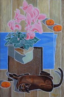 Table top with flower arrangement and Burmese cat rolling in front of it