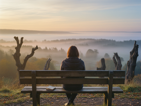 uma mulher sentada num banco olhando pensativa para as nuvens