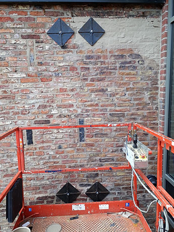 Hand-painted restoration mural of brickwork on an old building, progress picture
