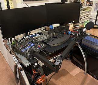 A desk setup with mouse, keyboard, microphone, etc.