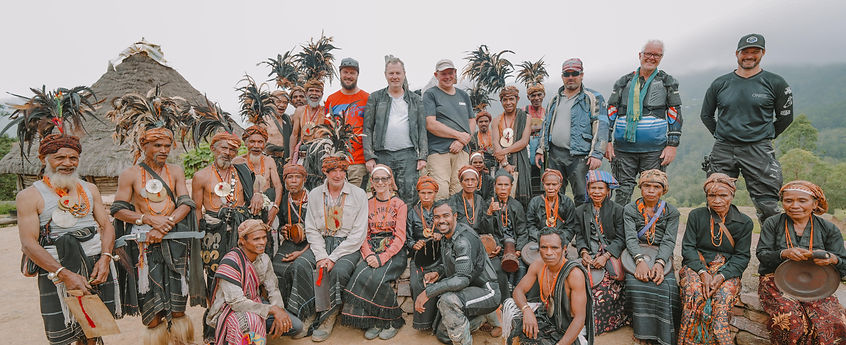 Motorcycle riders exploring and connecting with Timorese culture during a stop on a guided tour in Timor-Leste, with opportun