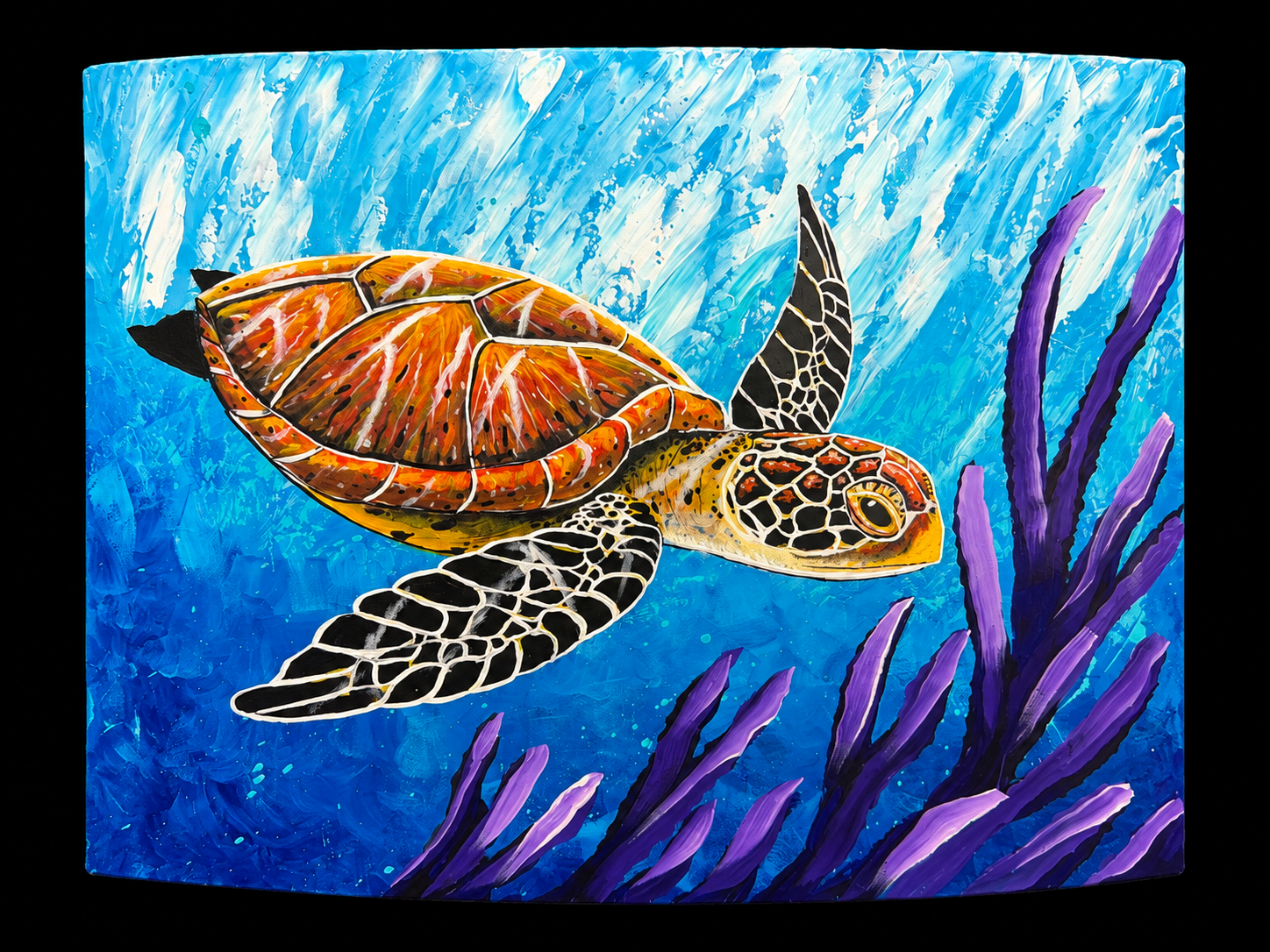 Sea turtle swimming through blue water and purple sea plants