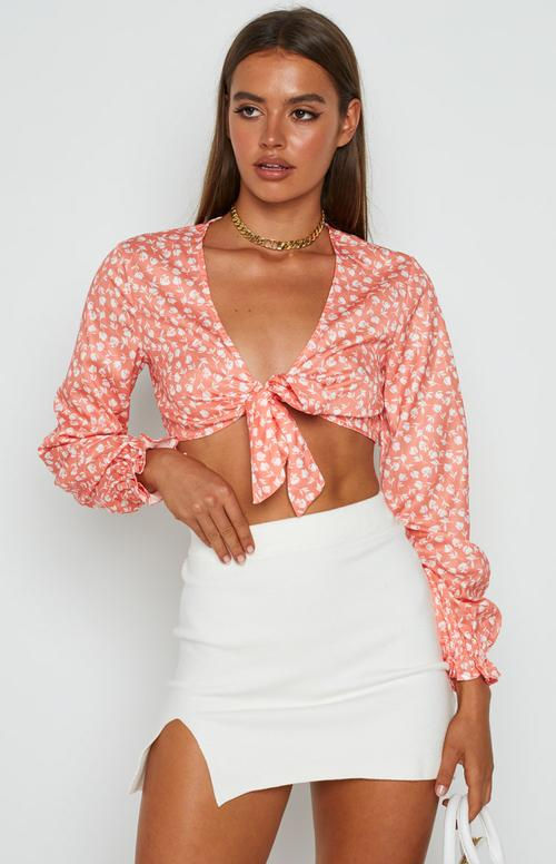 Miniatura: Mujer vistiendo crop top floral coral anudado con mangas largas.