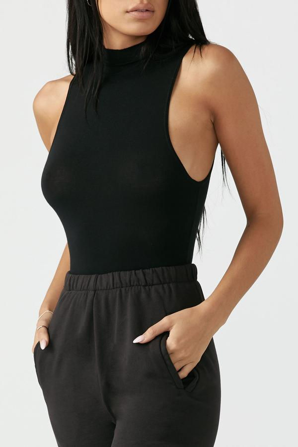 Miniatura: Mujer vistiendo top negro sin mangas y pantalones deportivos oscuros casuales.