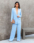 Miniatura: Mujer vistiendo elegante traje de pantalón azul celeste con cartera.