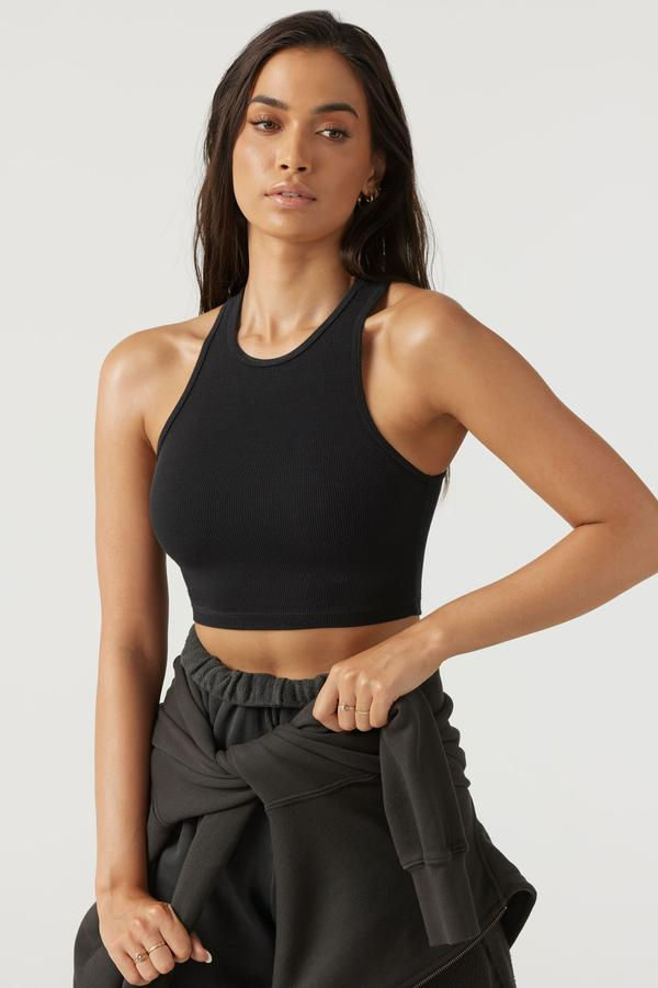 Miniatura: Mujer con top deportivo negro acanalado, ropa atlética casual.