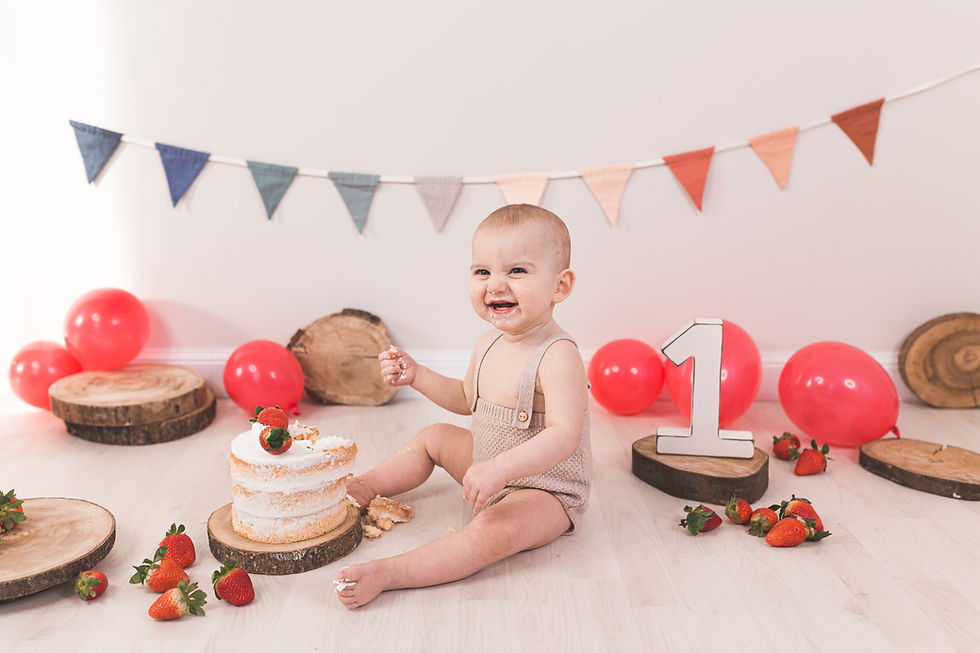 foto primo compleanno smash cake con torta nuda palloncini rossi e bandierine festa perego silvia fotografa