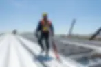 roofer+on+flat+metal+roof+with+harness-2880w.webp