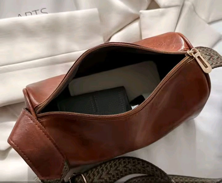 Thumbnail: Open brown leather cross-body bag, "DTC" on fabric, showing contents.