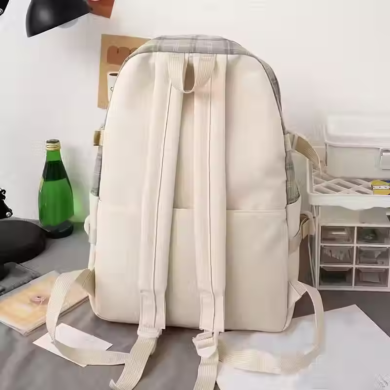 Rear view of a light cream backpack with padded shoulder straps.