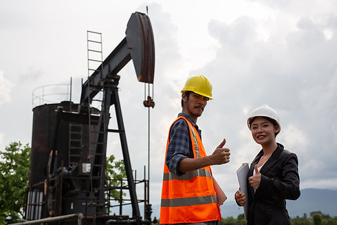female-engineers-consult-with-workers-working-oil-pumps-with-sky.jpg