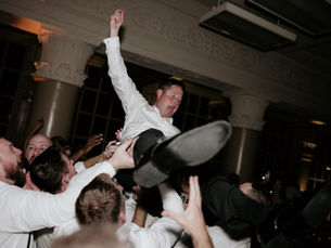 Groom crowd surfing over groomsmen at an elegant Houston wedding reception by AMP Events and Lighting