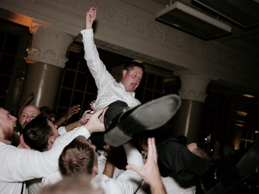 Groom crowd surfing over groomsmen at an elegant Houston wedding reception by AMP Events and Lighting