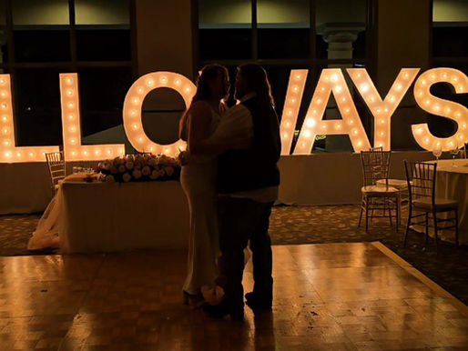 Couple's first dance in front of lit marquee letters at a Houston wedding reception by AMP Events and Lighting