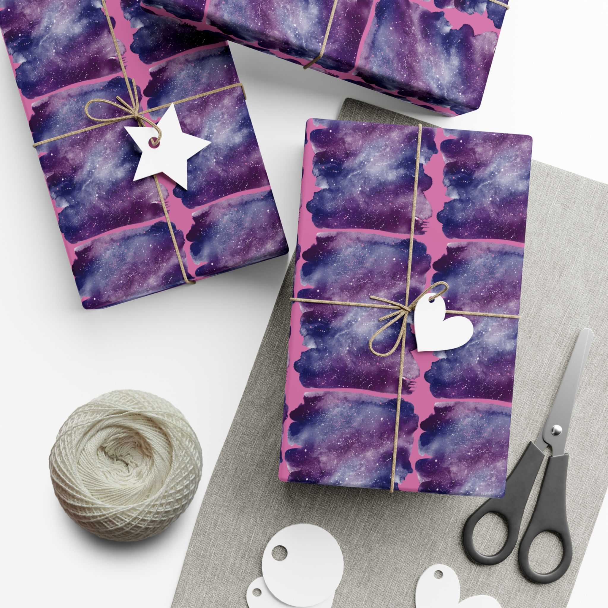 Wrapped gifts with purple watercolor paper, tags, and twine; Christmas gift wrap.
