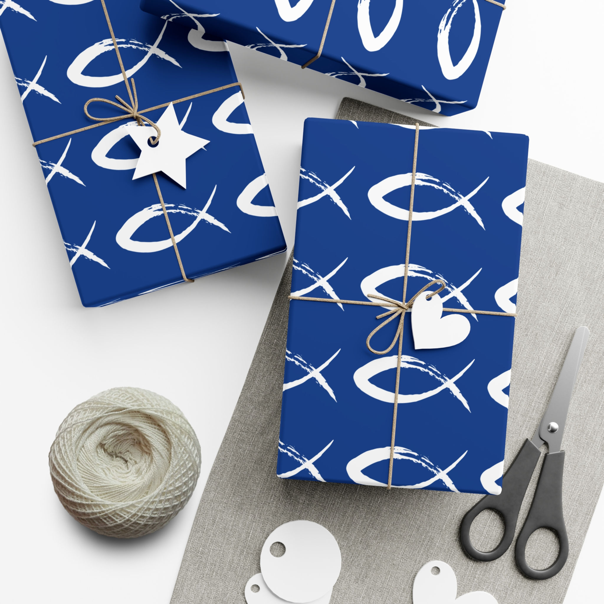 Blue gift-wrapped presents with white fish symbols and tags, string, and scissors.
