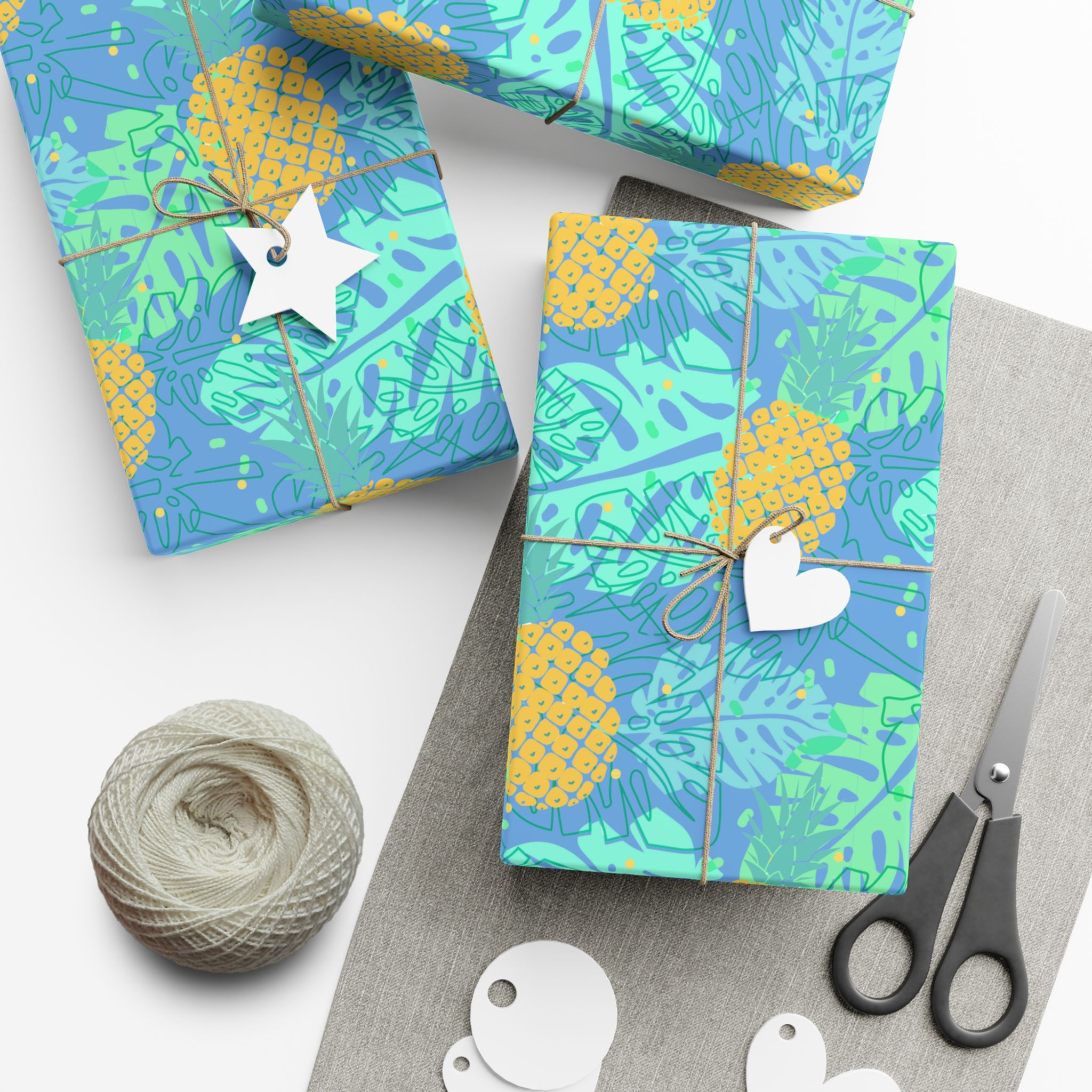 Wrapped gifts with Tropical Pineapple Beach Gift Wrapping Paper featuring blue wrap and leaves