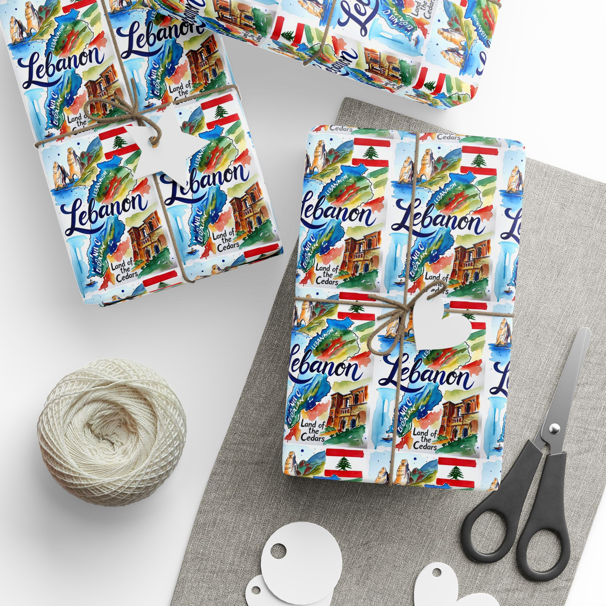 Wrapped gifts in 'Lebanon' paper showing Baalbek, Jeita Grotto, Mediterranean Coast.