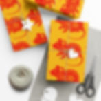 Wrapped gifts with red rat pattern, string, scissors and tags on the table