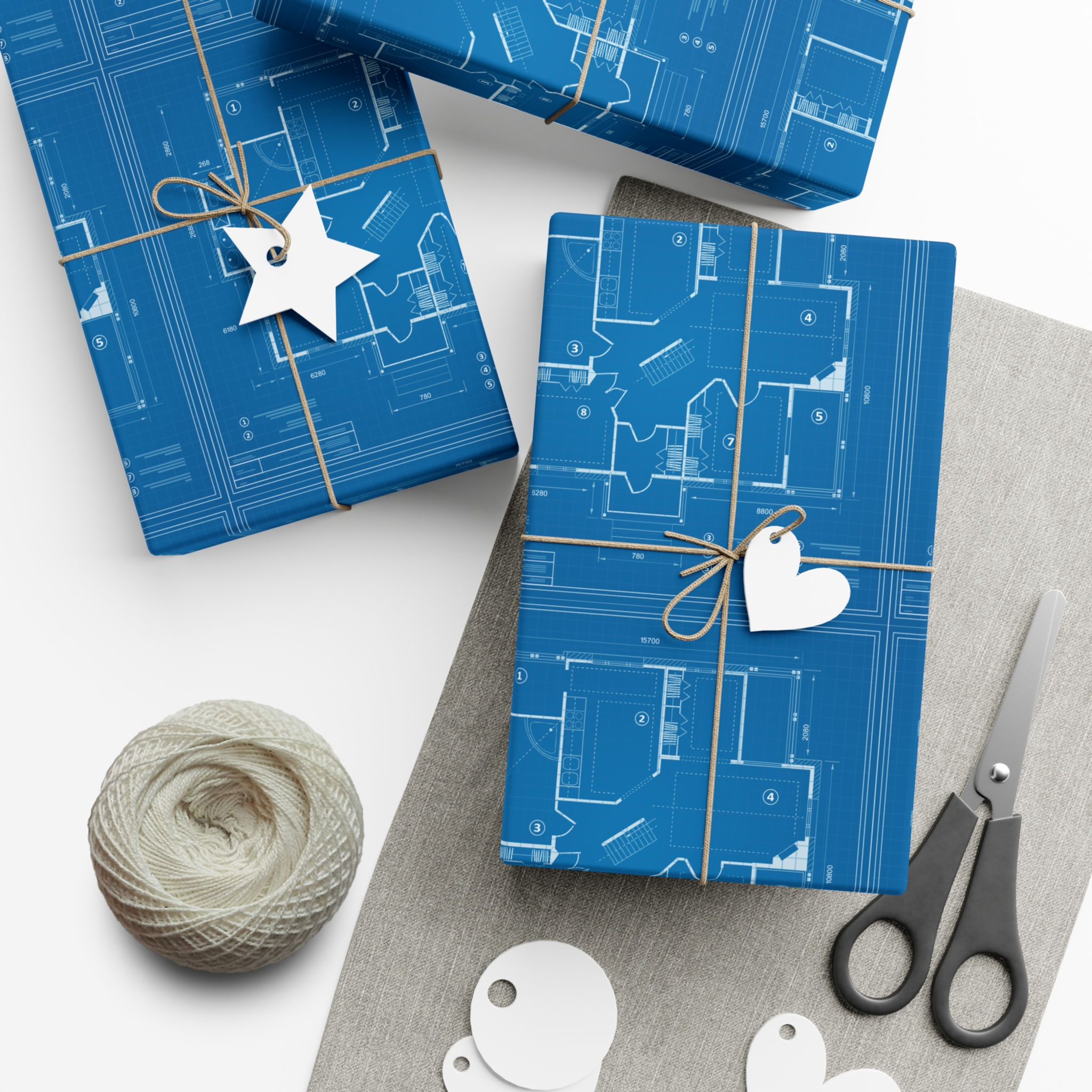 Wrapped gifts with blueprint design and gift tags on neutral background.