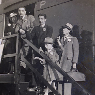 A black and white photo of a family getting onto a train