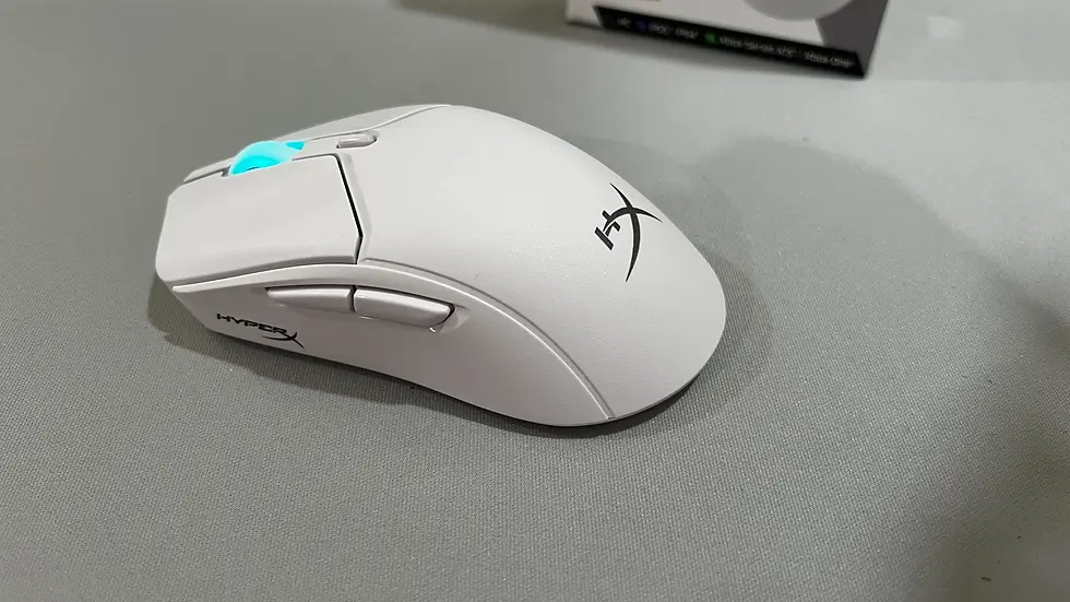 White HyperX gaming mouse with turquoise scroll wheel on gray surface. HyperX logo visible; minimalistic and sleek design.