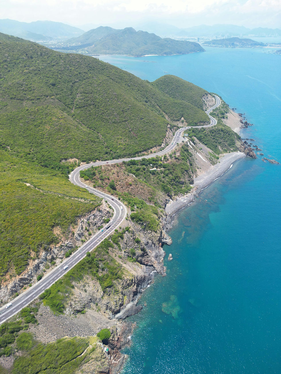 Coastal road in Vietnam with mountain views and blue sea for expats exploring summer travel in Vietnam