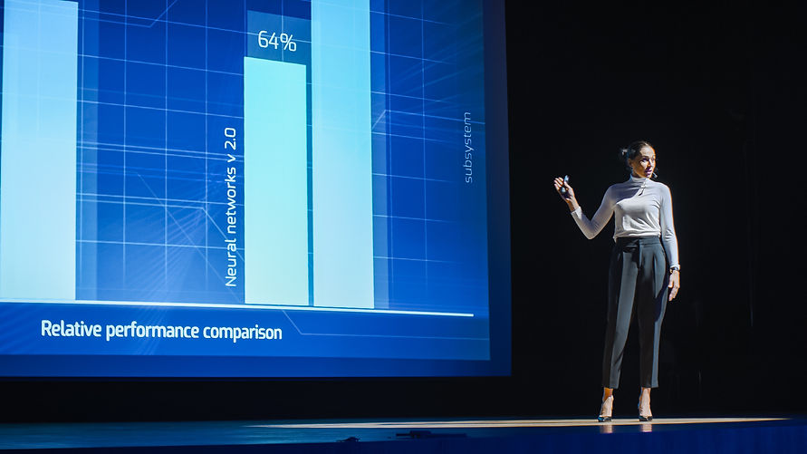 woman presenting slides on stage.jpeg