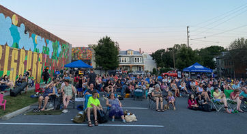 People sitting in the parking lot at the Midtown Cinema for the Outdoor Movie Series