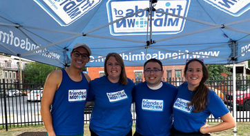 Friends of Midtown board members posing under a Friends of Midtown tent
