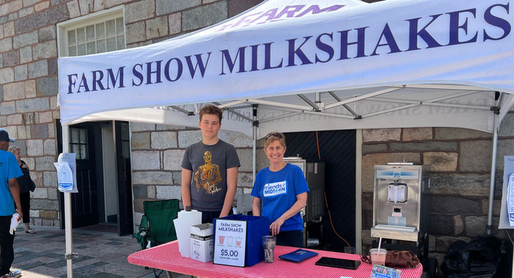 Two people working at the Farm Show Milkshake stand at the Broad Street Market