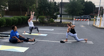 People doing yoga on a parking lot
