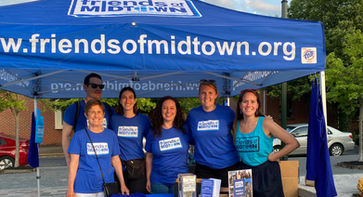 Friends of Midtown board members posing under a Friends of Midtown tent