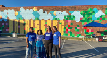 Group posing outside in front of the Harrisburg mural at the Midtown Cinema