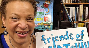 Woman holding a piece of paper that says "Friends of Midtown" on it in handwritten text
