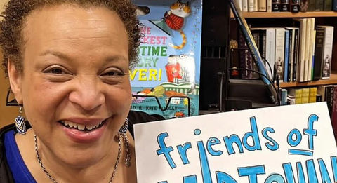 Woman holding a piece of paper that says "Friends of Midtown" on it in handwritten text