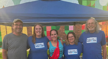 Friends of Midtown board members posing in front of a Friends of Midtown tent