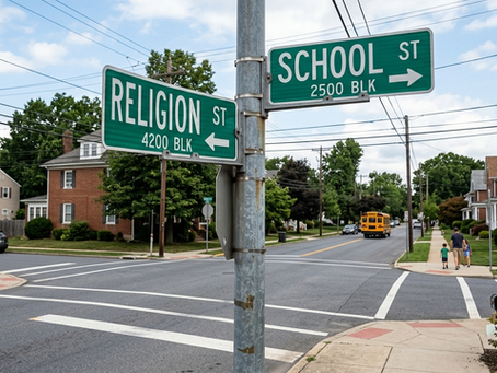 A street signpost at a suburban intersection showing two green signs pointing in opposite directions: "Religion St" pointing left and "School St" pointing right.