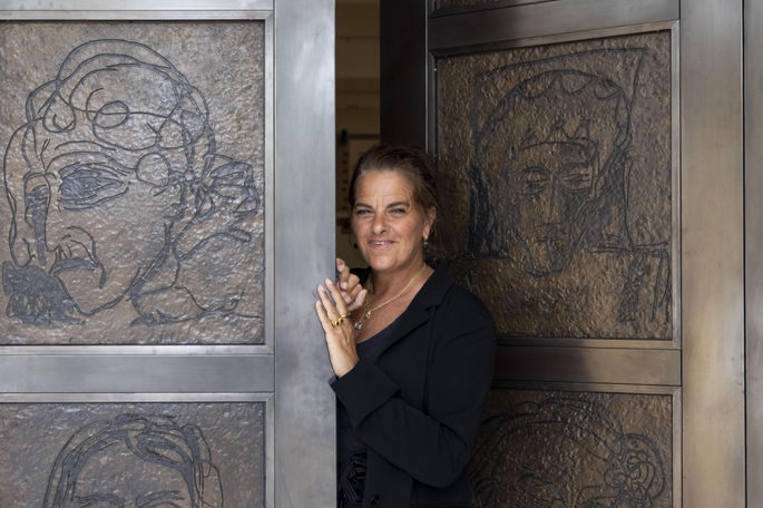 Tracey Emin beside her bronze doors at the National Portrait Gallery, adorned with expressive portrait reliefs