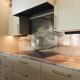A kitchen counter with sage green cabinets and gold fixtures
