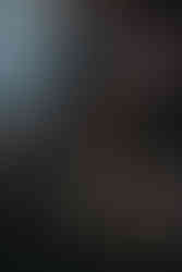 Boudoir on couch in speakeasy studio with art and neon light