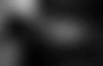 Boudoir hands on face leaning against bed