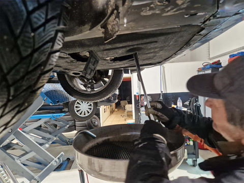 Öl wird aus Auto abgelassen von einem Automechaniker