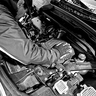 Mechaniker schraubt in Motorhaube