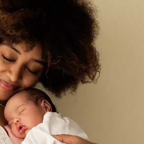 new mother in her fourth trimester snuggles her baby and feels well rested with overnight care from The Jax Baby Co.