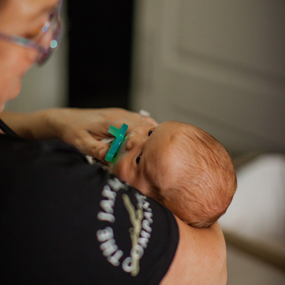 postpartum doula at The Jacksonville Baby Company soothing a newborn during overnight care.
